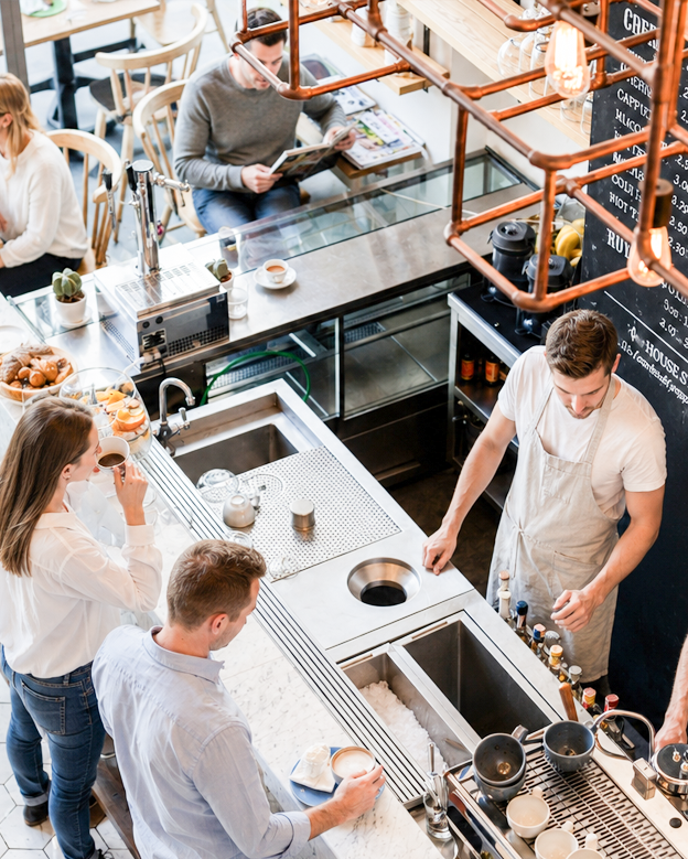 Zdjęcie restauracji – Bistro zrobione z góry. Na zdjęciu widać dobrze zaprojektowana przestrzeń elementy wizualne które podkreślają charakter miejsca.